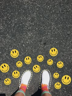 someone's feet standing in front of yellow smiley faces