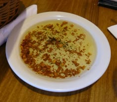 a white bowl filled with soup on top of a wooden table