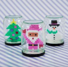 three glass jars with christmas decorations in them