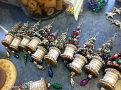 there are many bells that have been made out of paper and beads on the table