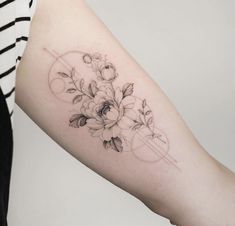 a woman's arm with flowers on it, and an arrow in the middle