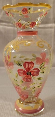 an ornate glass vase with flowers painted on it's sides and gold trimmings