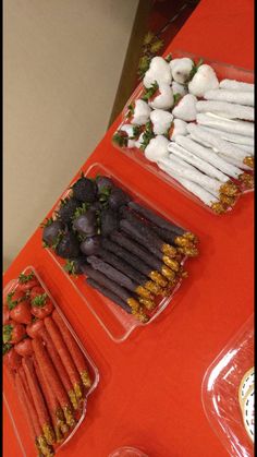 carrots, strawberries, and other vegetables are arranged on trays at a buffet table