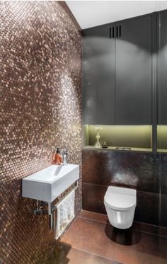 a bathroom with a toilet, sink and mirror on the wall next to each other