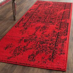 a red area rug with black and grey designs on the bottom in a living room