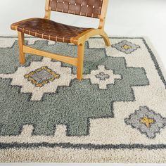 a wooden chair sitting on top of a rug