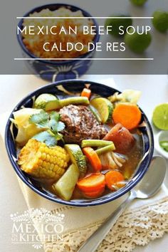 mexican beef soup with corn, carrots and celery in a blue bowl