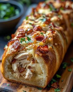 a long piece of bread with meat and cheese on it sitting on a cutting board