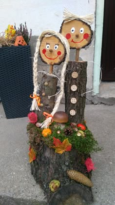 two scarecrows are sitting on top of a tree stump