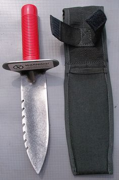 a knife and sheath laying next to each other on a gray surface with a red handle