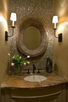 an image of a bathroom vanity with lights on the wall and a mirror above it