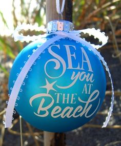 a blue ornament with the words sea you at the beach hanging from a pole