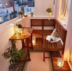 a wooden bench sitting on top of a balcony next to potted plants and candles