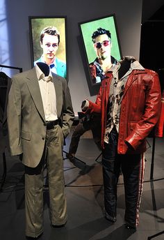 two mannequins dressed in suits and ties stand next to each other on display