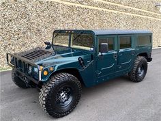 a green hummer truck parked in front of a building