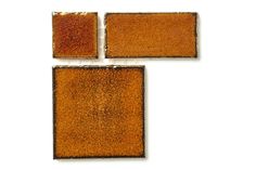 three square pieces of brown leather sitting on top of each other