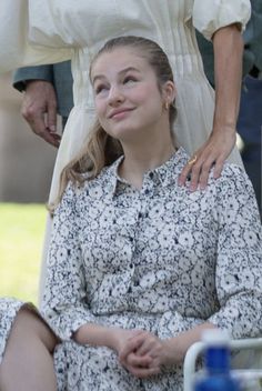 a woman sitting on top of a chair next to a man