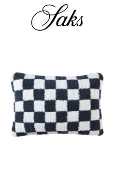 a black and white checkered pillow with the words faks written on it in cursive font