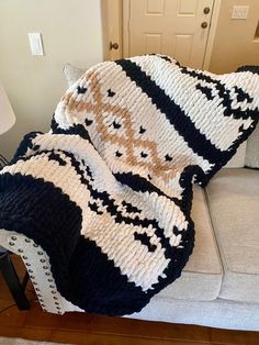 a white and black blanket sitting on top of a couch