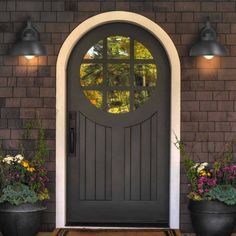 a front door with potted plants and lights