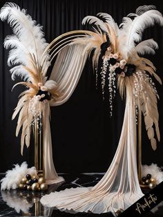 an elaborate wedding arch decorated with white and gold feathers