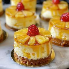 several desserts are arranged on a plate with raspberries and pineapple topping