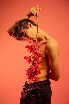 a man with no shirt holding a flower