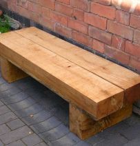 a wooden bench sitting next to a brick wall