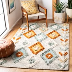 a living room area with a chair, potted plant and rug on the floor