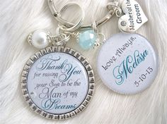 two personalized key chains are shown on a white furnishing surface, one has a thank you for raising your son to be the man of my dreams