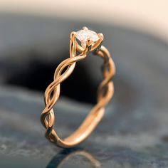 a yellow gold ring with a diamond in the center