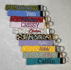 a bunch of key chains that are on top of a white surface with words written on them