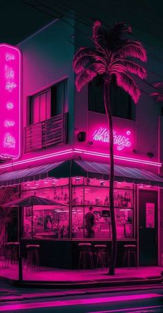 a neon lit building with palm trees in the foreground