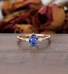 a tan gold ring with an oval blue sapphire and three diamonds