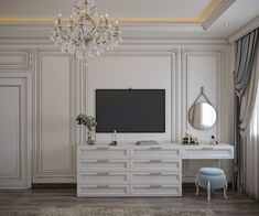 a room with a tv, dressers and a chandelier hanging from the ceiling