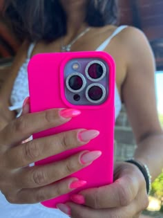 a woman holding a pink cell phone case in her right hand and looking at the camera