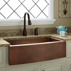 a kitchen sink with an intricate design on the front and side, next to a window