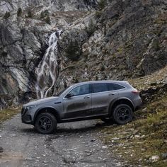 the mercedes gle is parked in front of a waterfall