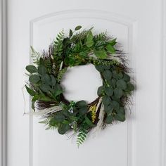 a white door with a green wreath hanging on it