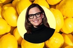 a woman wearing glasses standing in front of a pile of lemons with a yellow circle around her