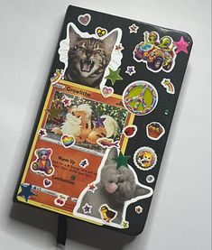 a notebook covered in stickers with a cat on the front and an elephant on the back