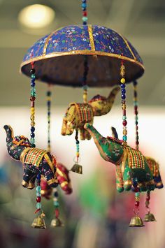 an elephant and giraffe wind chime hanging from a ceiling