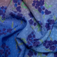 the fabric is blue and has purple flowers on it