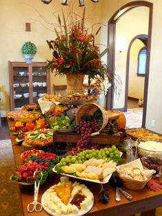 a table filled with lots of different types of food on top of wooden trays