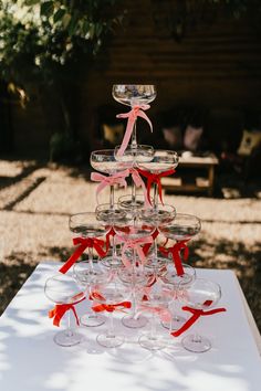 several wine glasses stacked on top of each other with ribbons tied around the rims