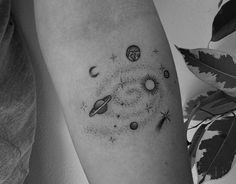 a black and white photo of a person's arm with tattoos on it