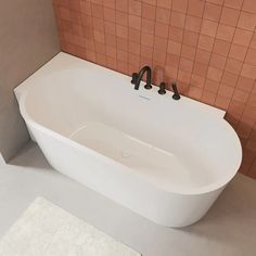 a white bath tub sitting in a bathroom next to a brown tiled wall and floor