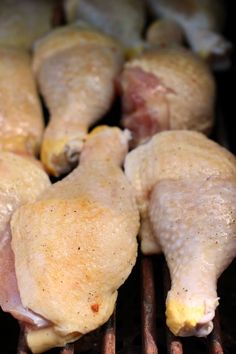 several pieces of chicken cooking on a grill