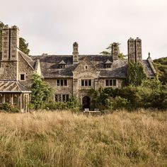 an old stone house surrounded by tall grass