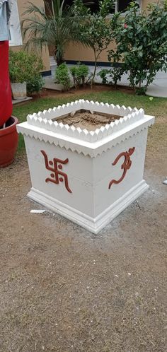 a large white box sitting on top of a dirt field next to a red fire hydrant